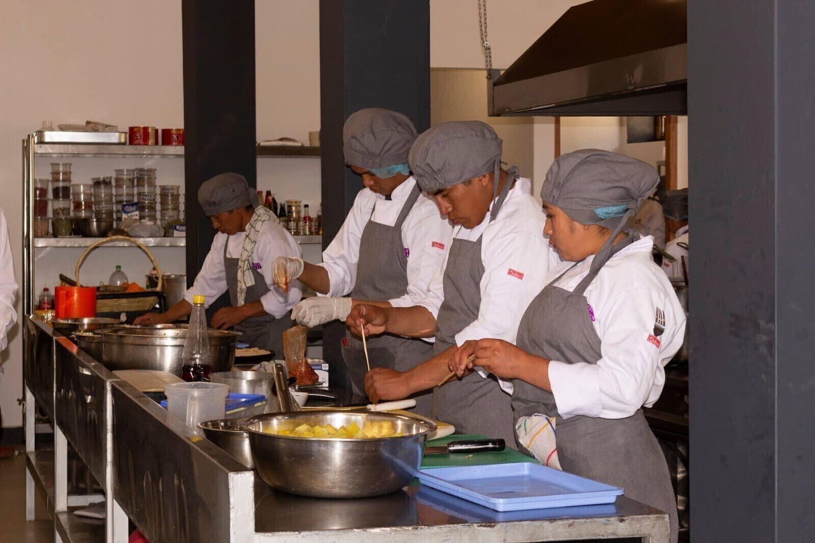 Jóvenes del centro de formación preparando platos en la cocina